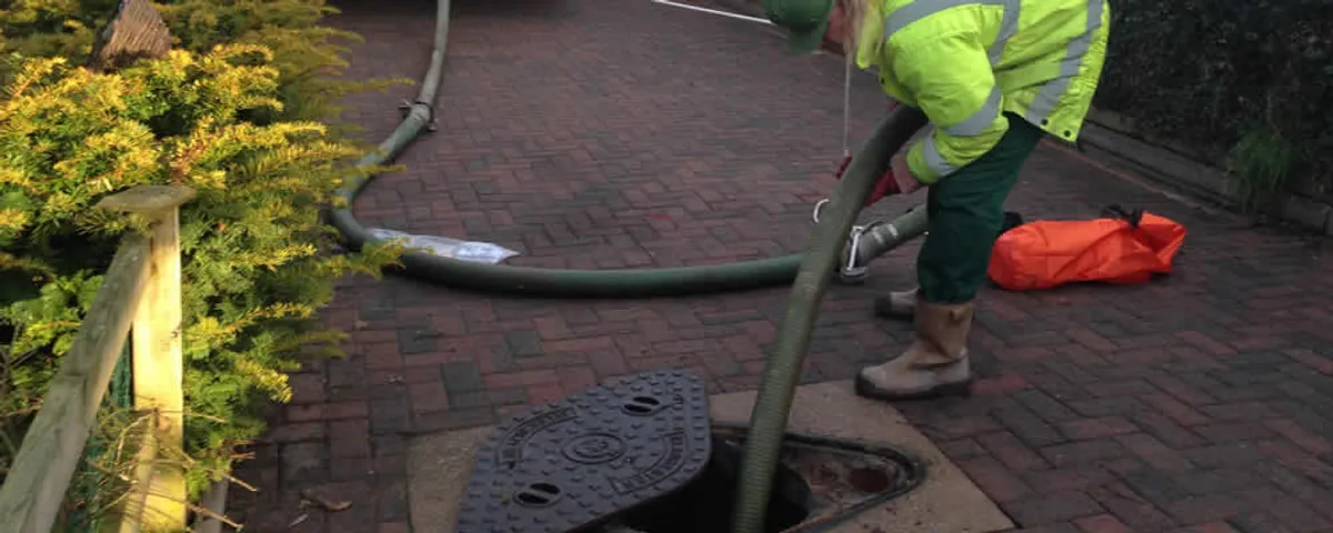 Septic tank cleaning technician servicing a septic tank with a vacuum hose in Oak Park, IL