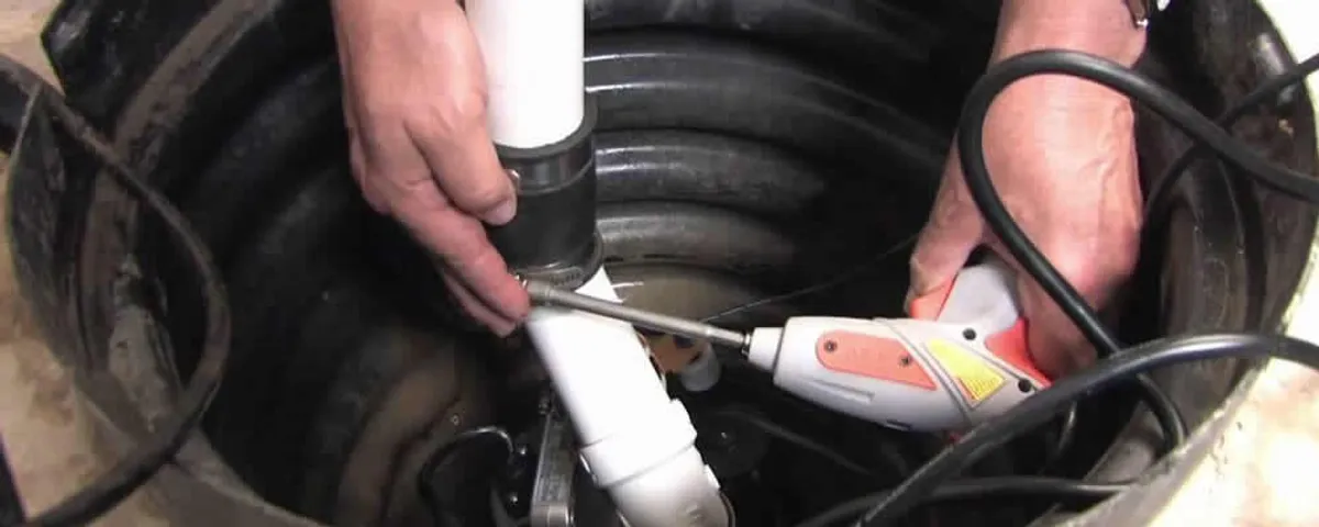 Sump pump installation technician connecting PVC discharge piping in Oak Park, IL