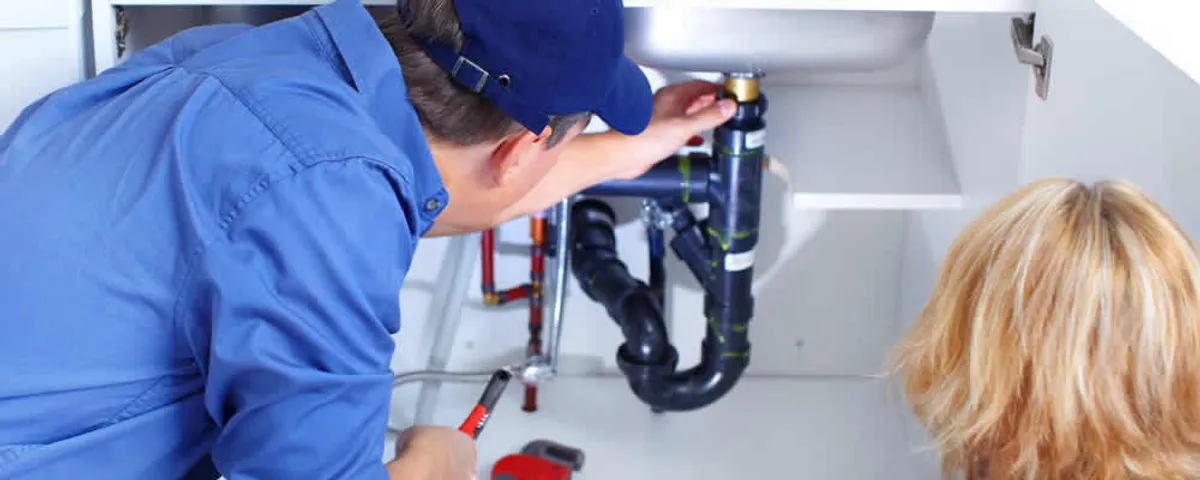 Plumber repairing under-sink drain pipes and fittings in Oak Park, IL